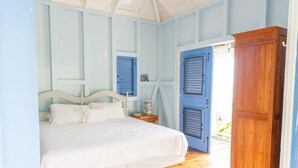 A bedroom with a bed, wooden floor, and a wardrobe.