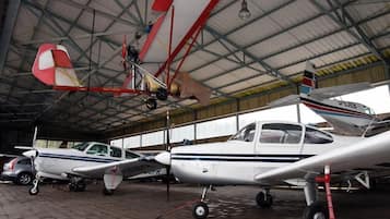 A hangar with multiple small aircraft parked inside.