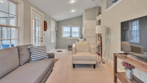 A living room with a sofa, armchair, and a television on a stand.