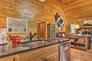 Enjoy cooking in this cabin's well-appointed kitchen, featuring a granite countertop, stainless steel sink, and dishwasher.