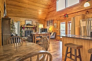 Cozy cabin-style interior with a dining area, seating area, and kitchen.