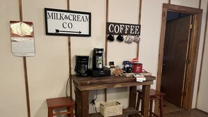 A wooden coffee station with a coffee maker, mugs, and a calendar. - Fenced for your fur babies! 2 cabins on property for 1 price! (Mena)