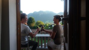 Two people seated on a balcony with a mountain view. - Dream vacation apartment in an elevated position with unobstructed views (Lenggries)