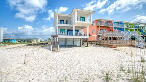 A beachfront property with a multi-story building featuring balconies and a covered area. - A Bitter Acorn: Newly Built, Gulf Front Home | Navarre Beach (Navarre Beach)