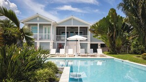 A two-story house with a swimming pool, white railings, and a covered patio area. - Waterlane House at Lunara Bay (Key West)