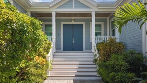 A two-story house with a front porch, a double door, and a number '8' on the door. - Waterlane House at Lunara Bay (Key West)