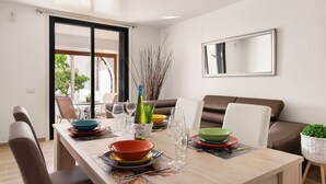 A dining area with a table set for four, a sofa, and a large mirror on the wall. - "Piece of Ocean by Mea Substantia" (Playa de la Américas)