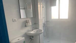Ein modernes Badezimmer mit Toilette, Waschbecken und Dusche.