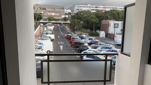 Ein Balkon mit Blick auf einen Parkplatz und Gebäude.