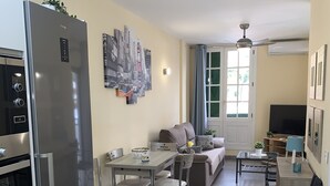 Eine moderne Küche mit Kühlschrank, Backofen und Essbereich mit Stühlen und Tisch.