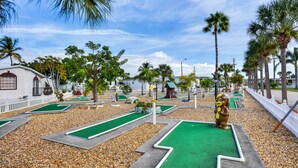 A miniature golf course with multiple green lanes and a mascot statue. - Nettles Island Jensen Beach Home: Walk to Ocean! (Jensen Beach)