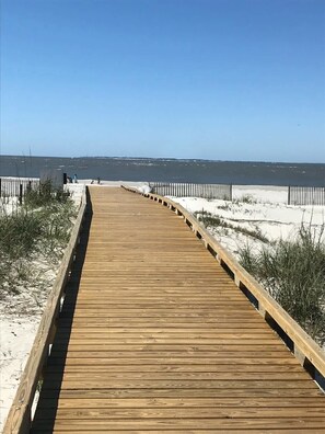 A wooden boardwalk leading to a beach with a clear sky. - Luxury Villa, w/ Patio Steps to Beach Hilton Head (Hilton Head Island)