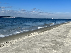 Enjoy a serene beach experience with a wide sandy shore and calm sea.