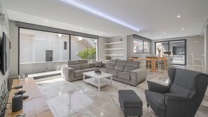 A modern living room with a sectional sofa, a grey armchair, and a coffee table.