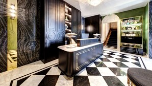 A luxurious lobby with a marble floor, a reception desk, and a staircase leading to another area. - 1877 Estrela Palace Hotel (Aveiro)