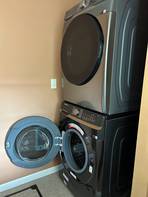 A stacked washer and dryer unit in a room with beige walls. - Great Location, relax by Sandpoint City Beach Park or shop downtown (Sandpoint)