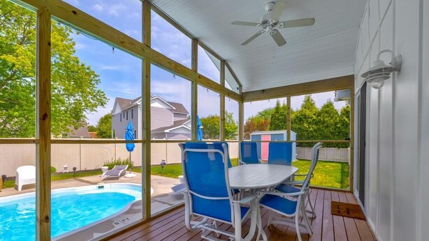 Un espacio al aire libre techado con piscina, terraza de madera y asientos.