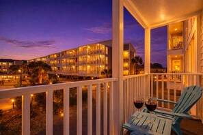 A hotel balcony with a view of a multi-story building at dusk. - BEACH TIME! Serene 3BR Condo -Pelicans Landing 132 (Myrtle Beach)