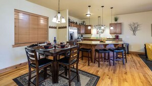 Una cocina moderna con armarios de madera, una isla central e iluminación colgante.