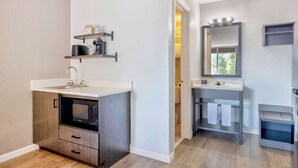 A compact bathroom with a sink, mirror, and shelves. - Studio 6 Effingham, Il (Effingham)