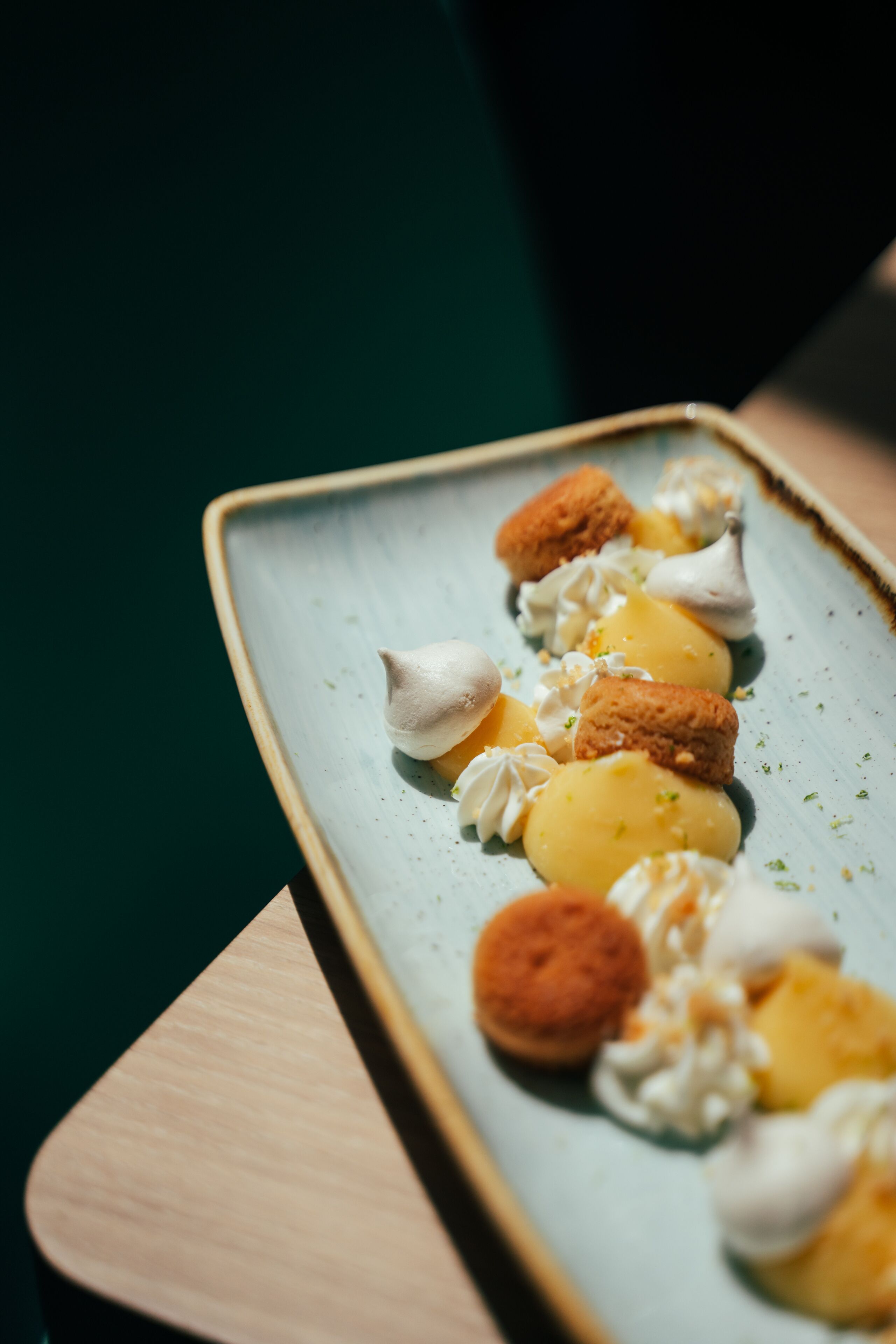 Un plato de postres con dulces y merengues sobre un recipiente de cerámica.