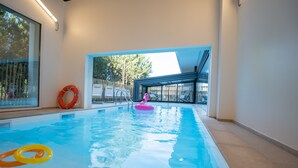 An indoor swimming pool with clear blue water, a pink flamingo float, and a red lifebuoy. - Holiday Inn Bordeaux-Merignac by IHG (Merignac)