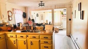 Une cuisine dotée d’un grand îlot central, de meubles en bois et d’un coin repas avec un canapé et une table.