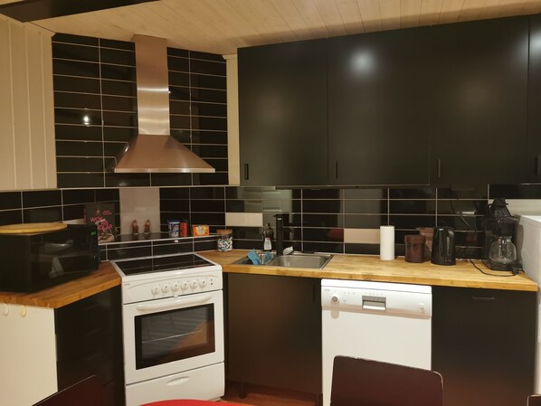A modern kitchen with a stove, oven, dishwasher, and a sink. - Modern guesthouse in the middle of Torhamn (Blekinge län)