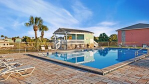 A swimming pool with lounge chairs and a covered area. - The Beach Bungalow - In the Heart of Destin, FL!   (Destin)