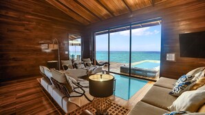 A wooden interior with a pool, lounge area, and ocean view.