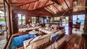 A spacious living area with a large sofa, a coffee table, and a view of the ocean.
