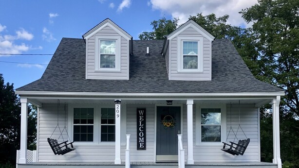 A two-story house with a porch, two windows, and a 'WELCOME' sign. - Bright and Serene Country Cottage in the Blue Ridge Mountains (Hillsville)