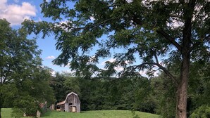 A rural landscape with a wooden fence, a barn, and a grassy hill. - Bright and Serene Country Cottage in the Blue Ridge Mountains (Hillsville)