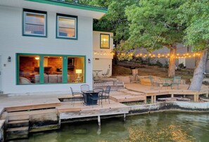 Une maison avec une terrasse et un étang.