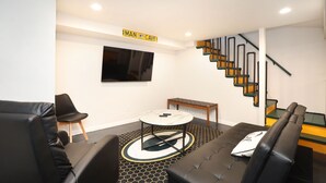 A modern living room with a sofa, chairs, a coffee table, and a staircase. - Beautiful newly remodeled house .5 miles to Lambeau/Resch center. (Pet Friendly) (Green Bay)