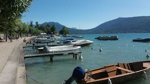 A marina with boats docked, a docked boat in the foreground, and a mountainous backdrop.