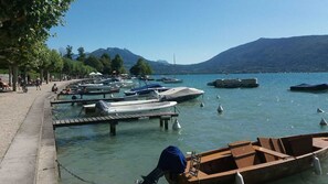 A marina with boats docked, a docked boat in the foreground, and a mountainous backdrop.