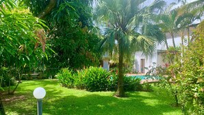 A lush garden with a swimming pool, palm trees, and a well-maintained lawn. - chacaradaspalmeiras512 -Inoan-Marica-RJ-lots of greenery, swimming pool, sauna, (marica)