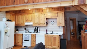 Una cocina amplia con armarios de madera, una estufa y un lavamanos.