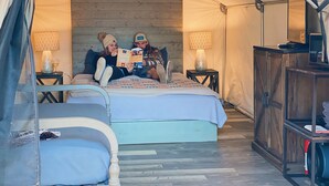 A tented accommodation with a bed, two bedside lamps, and a wooden cabinet. - Son's Blue River Camp - Glamping Cabin #1 (Kingsbury)