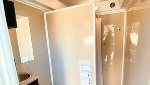 A compact bathroom with a toilet, sink, and mirror. - Son's Blue River Camp - Glamping Cabin #1 (Kingsbury)