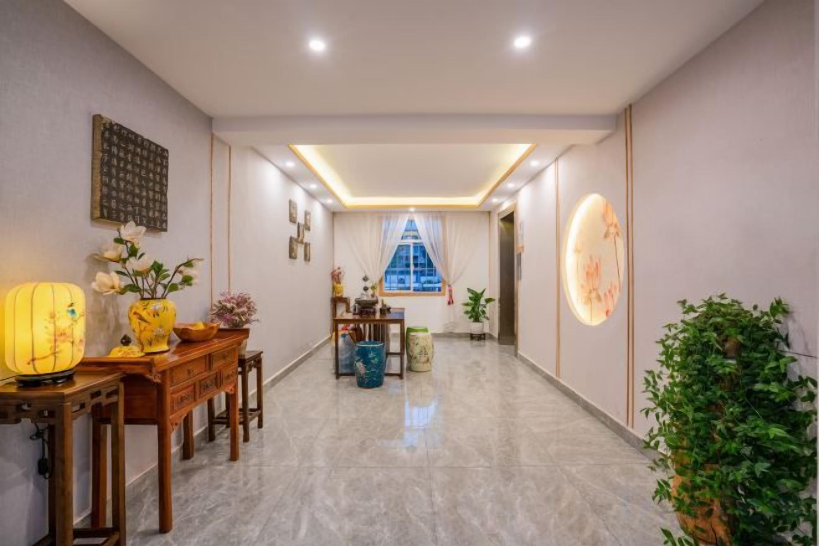 A hotel lobby with a reception desk, a dining area, and a large window with curtains.