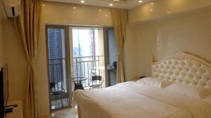A hotel room with a large bed, a balcony with a chair, and a ceiling light fixture. - Chenxi Hotel Apartment (Nanning)