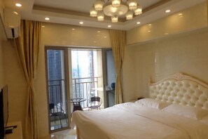 Habitación de hotel con una cama grande, un candelabro, un balcón con una silla y vistas a la ciudad.