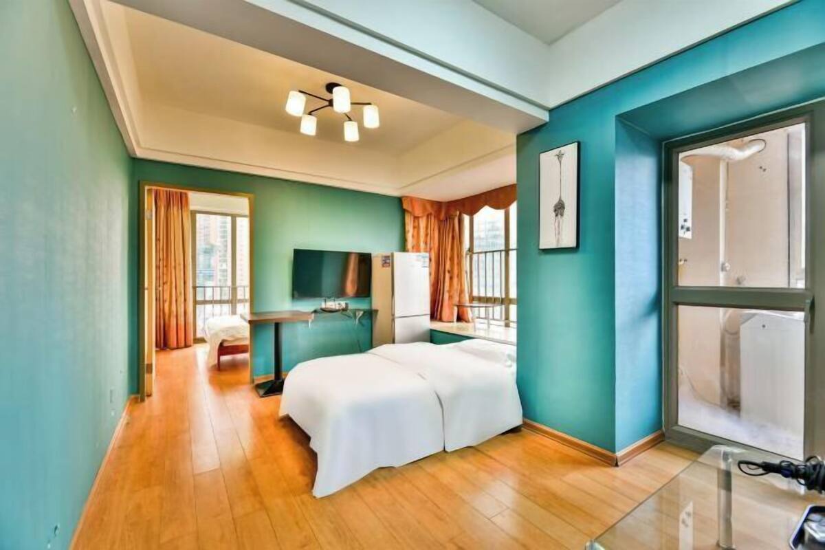 Habitació d'hotel amb llit, escriptori, televisió i finestra.
