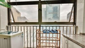 A kitchen with a window, a water dispenser, and a shoe rack. - Chenxi Hotel Apartment (Nanning)