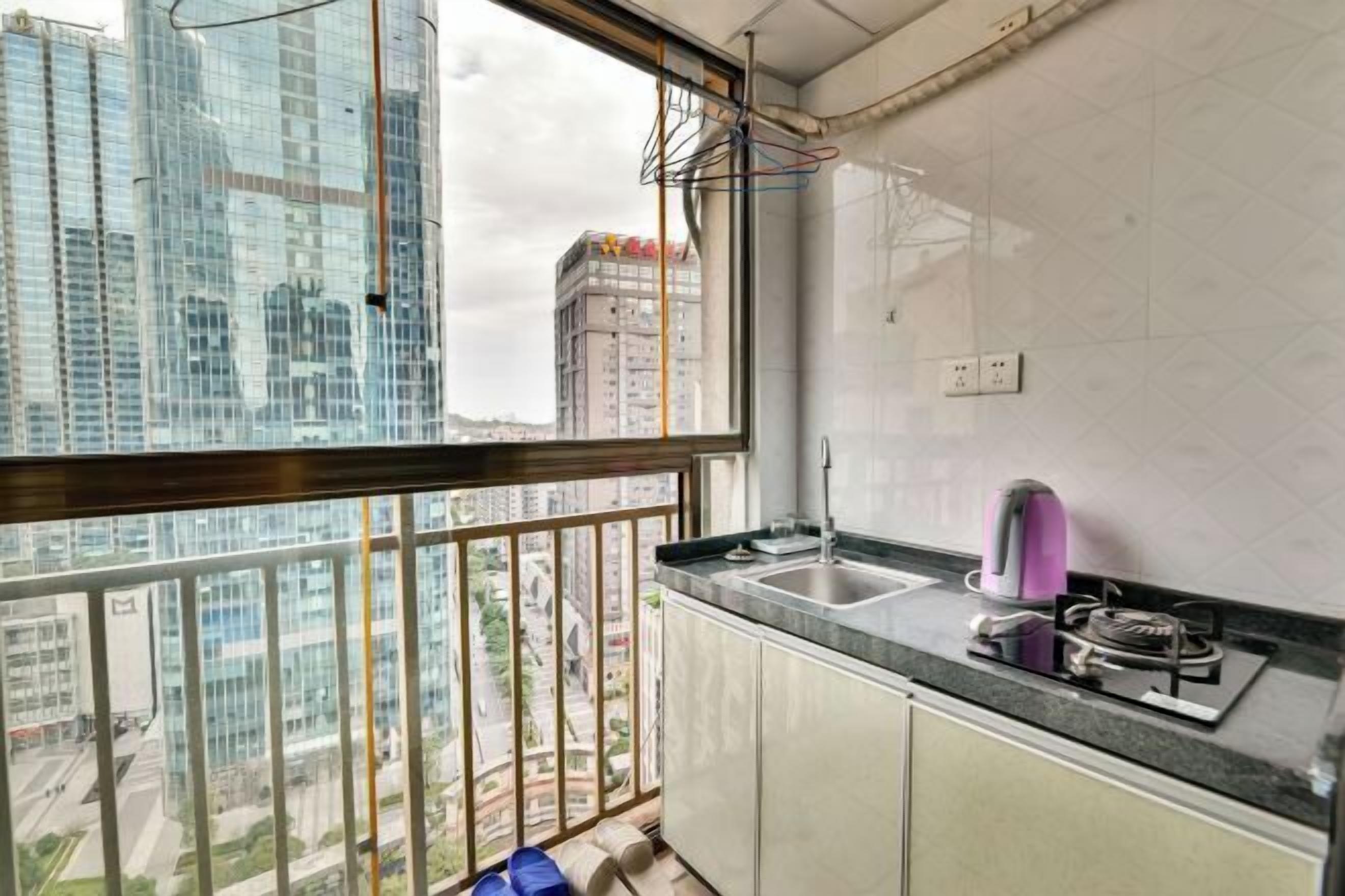 A kitchen with a view of a cityscape, a gas stove, and a sink.