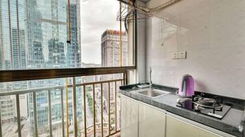 A kitchen with a view of a cityscape, a gas stove, and a sink.