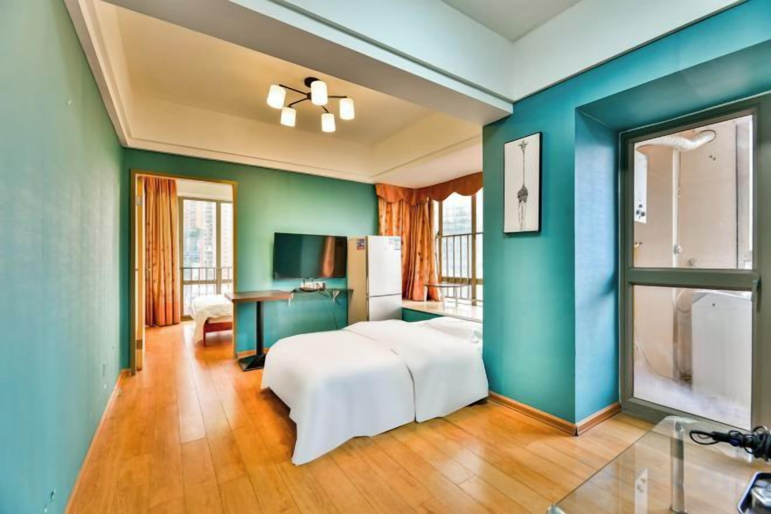 Una habitación de hotel con una cama, televisor, escritorio y ventana.