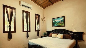 Un dormitorio con cama, cortinas, aire acondicionado de pared, un cuadro y techo de madera.